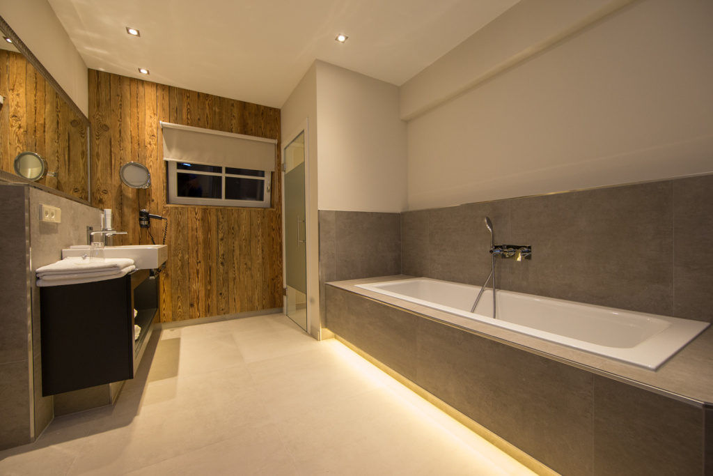 Modernes Badezimmer mit Badewanne und Holzverkleidung