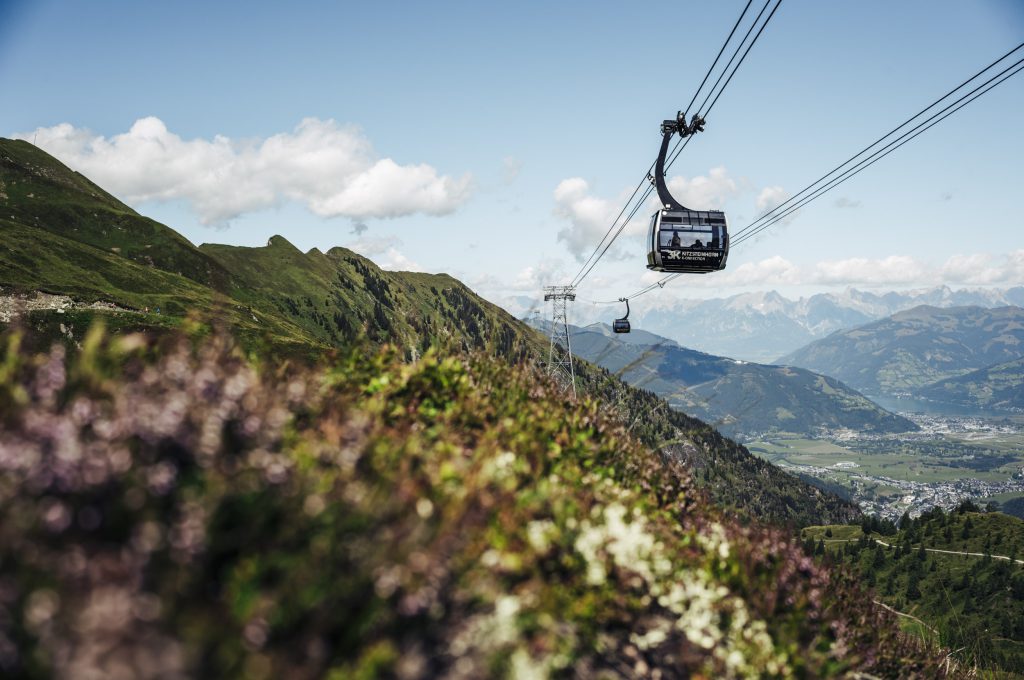 Seilbahn über grüne Berghänge mit Blick ins Tal